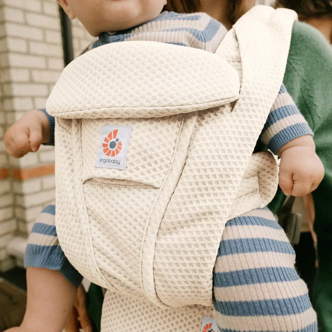 Ein Baby wird in einem weißen Babytrage getragen