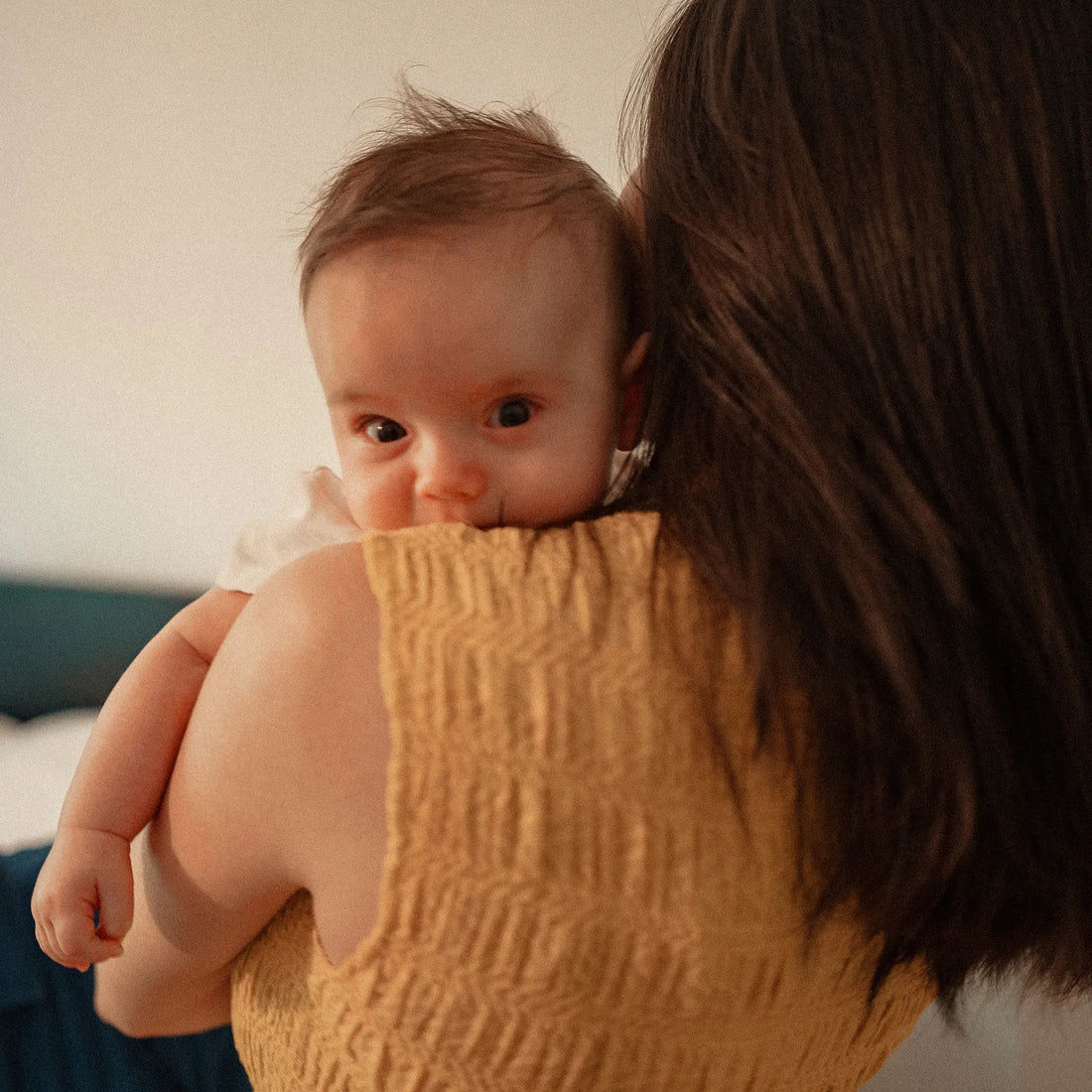 Woman holding a baby looking over her shoulder