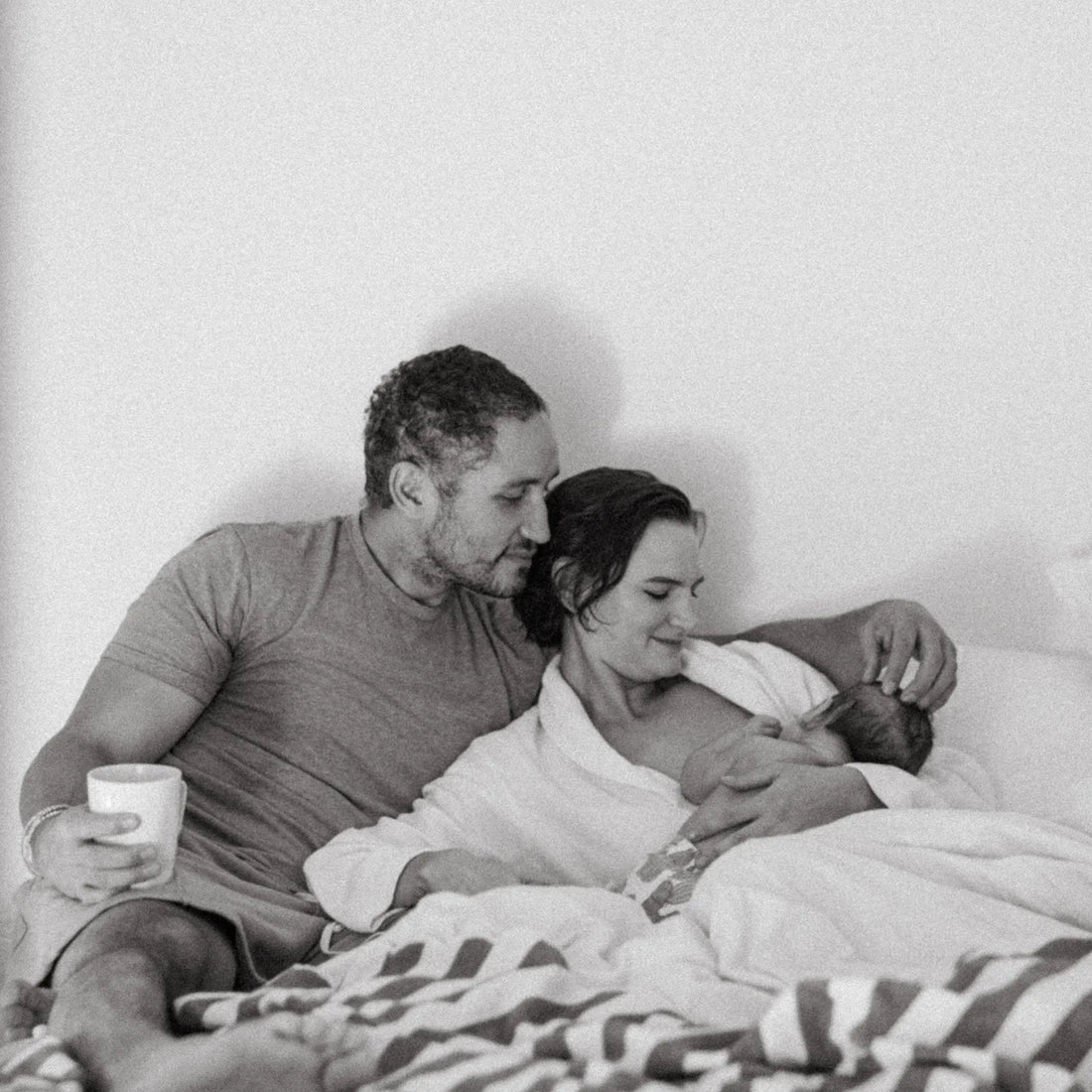 En man och en kvinna ligger i sängen medan kvinnan ammar