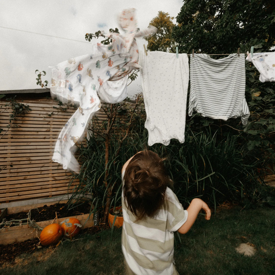 Ein Kind betrachtet Kleidung, die draußen an einer Leine hängt