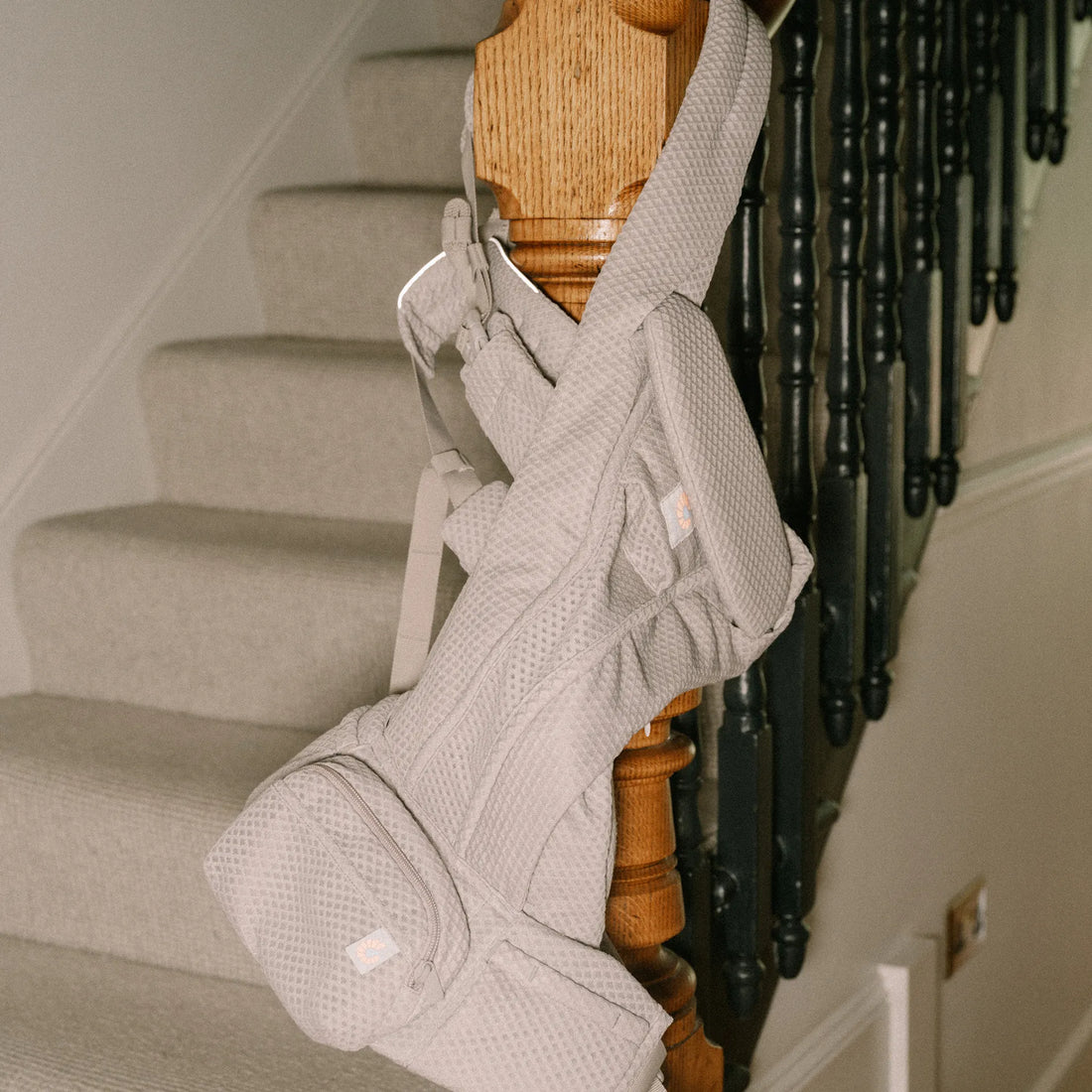 Porte-bébé gris clair suspendu à un poteau