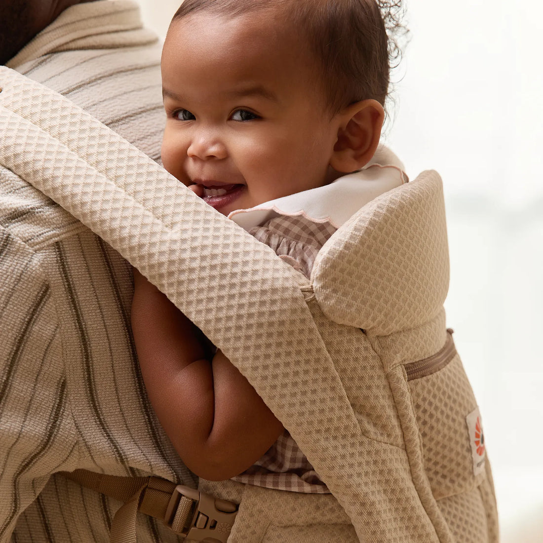 Bébé dans un porte-bébé beige tissé