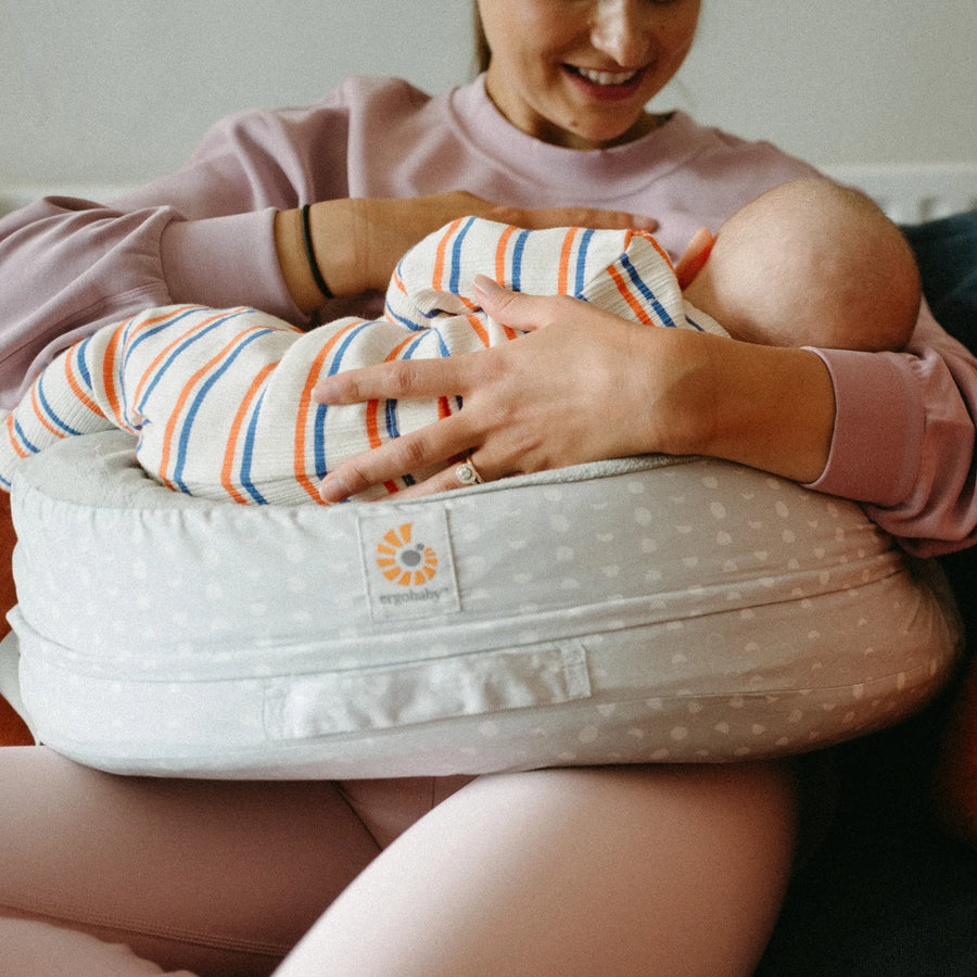 Frau, die ihr Baby mit einem Stillkissen stillt