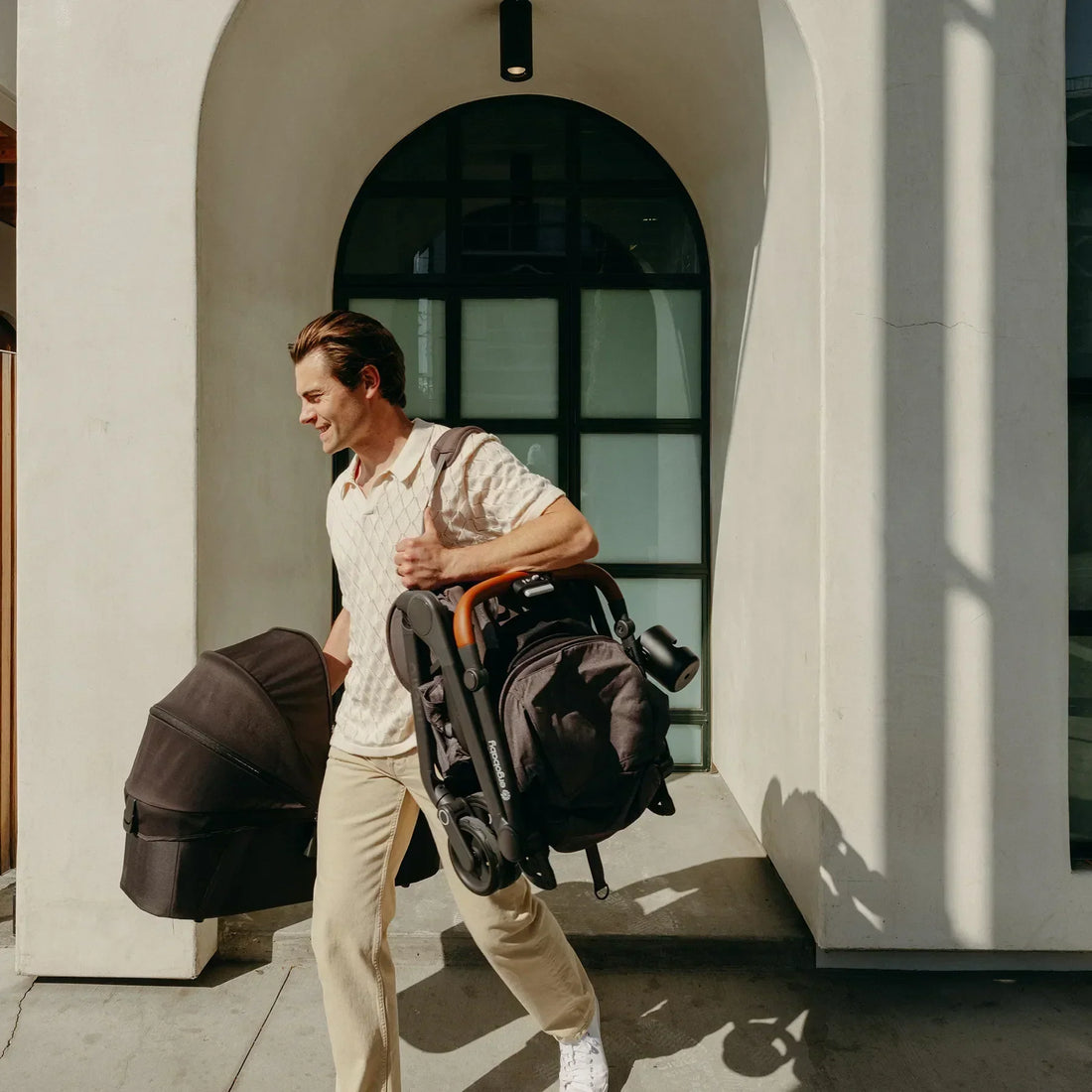 Man carrying a travel stroller