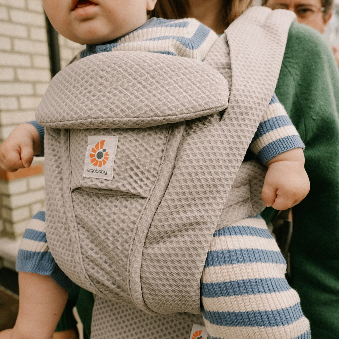 Baby in einer grauen Babytrage