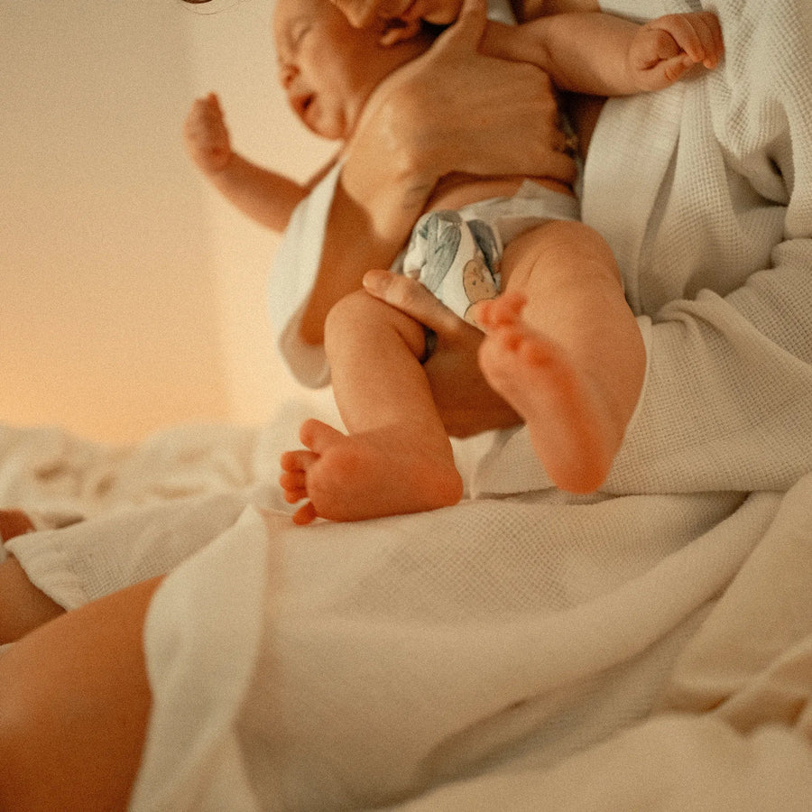 Eine Person, die ein weinendes Baby im Arm hält