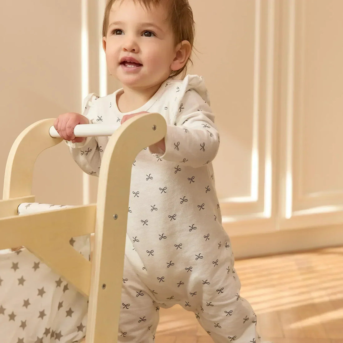 Ein Baby schiebt einen Spielzeugkinderwagen