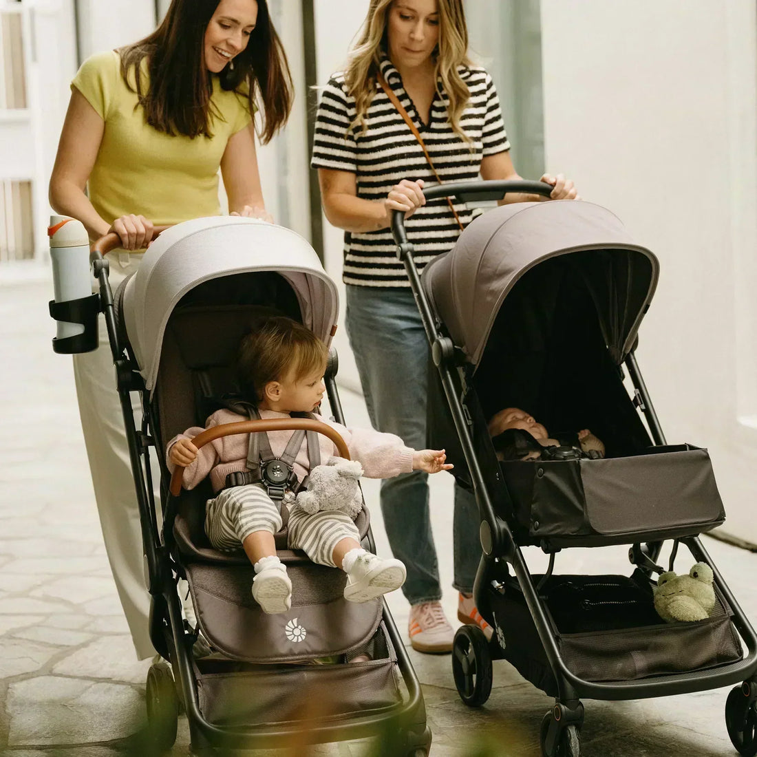 Zwei Frauen, die Kinderwagen schieben 