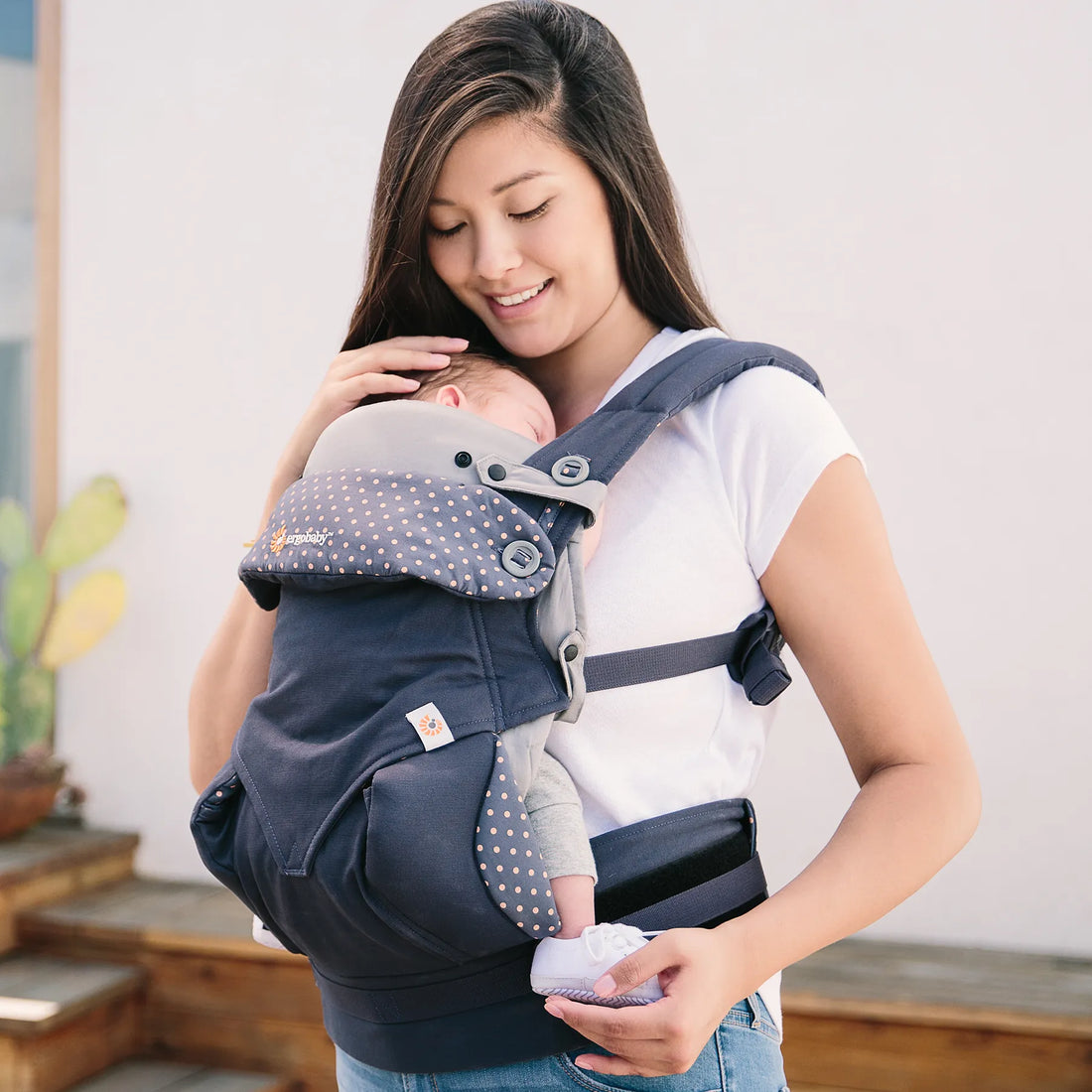 Femme tenant un bébé dans un porte-bébé bleu