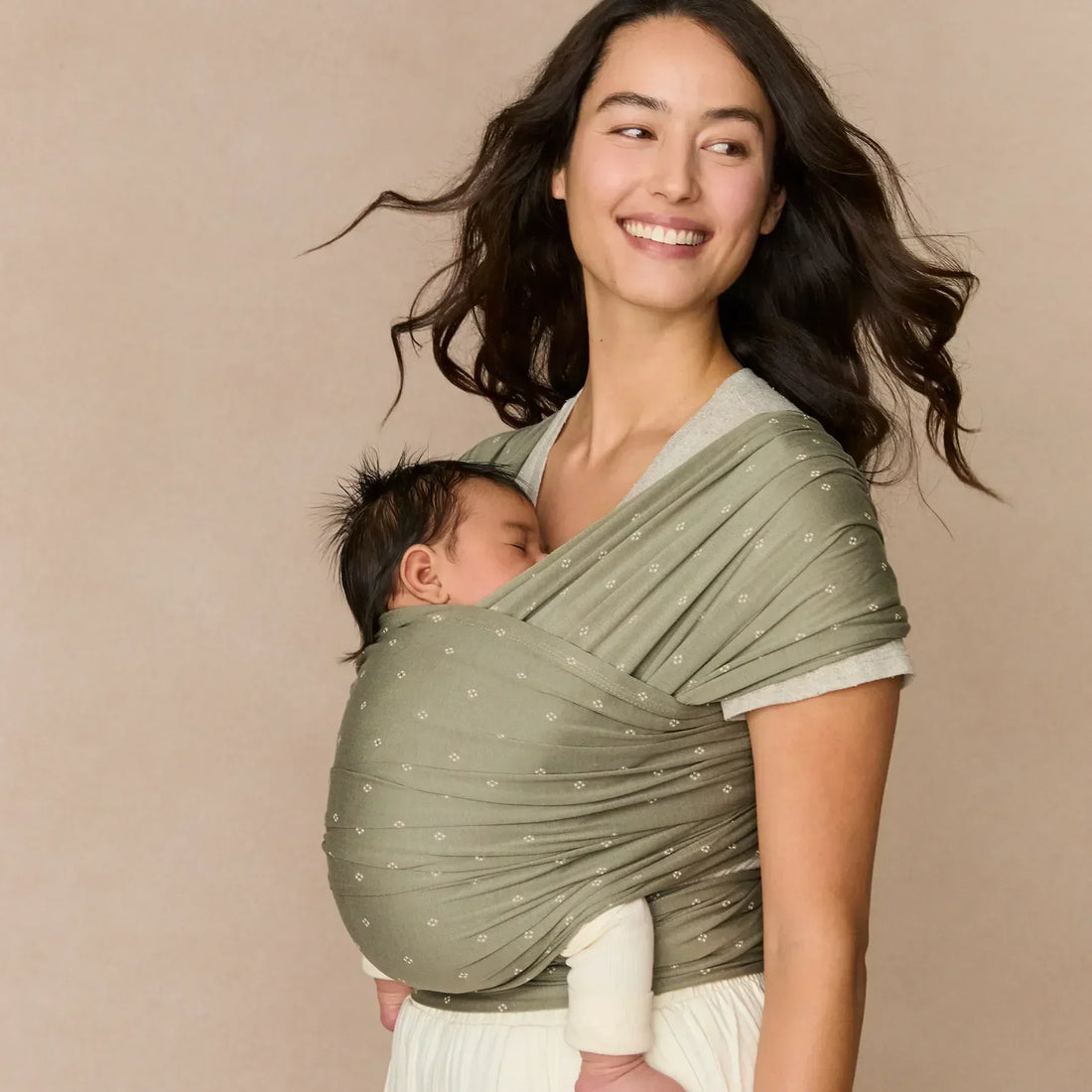 Femme tenant un bébé dans un écharpe 