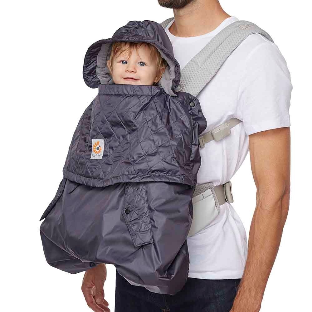 Dad wearing baby outward facing with All Weather Carrier Cover