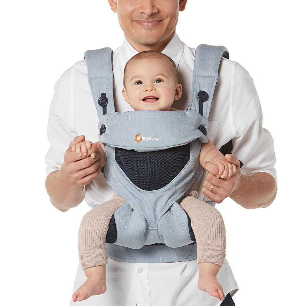 Papa porte son bébé face vers l'extérieur dans le porte-bébé 360 All Positions en chambray