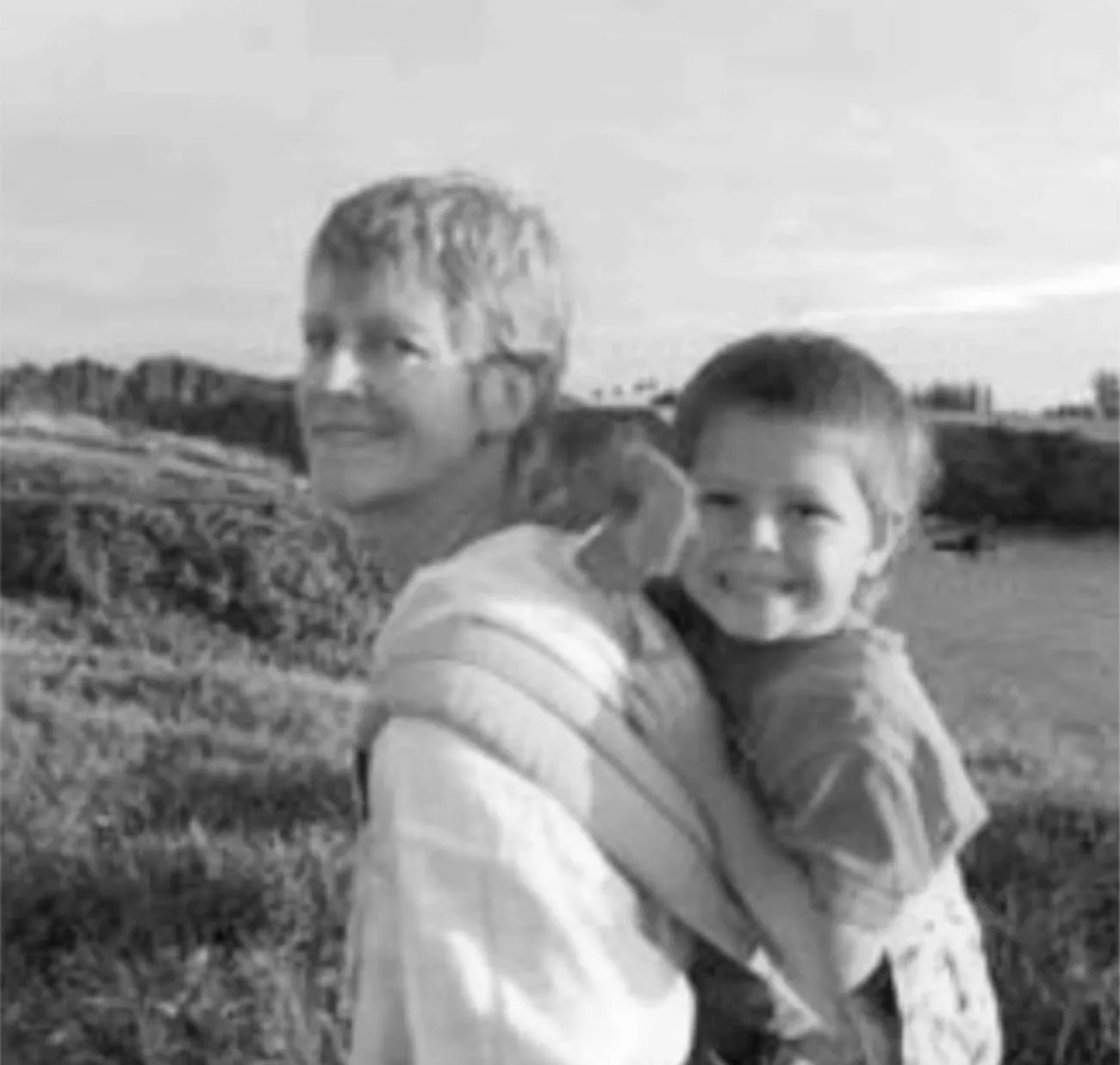 Schwarz-Weiß-Foto von Karin Front, die ihr Kleinkind in der ersten Ergobaby-Trage trägt.